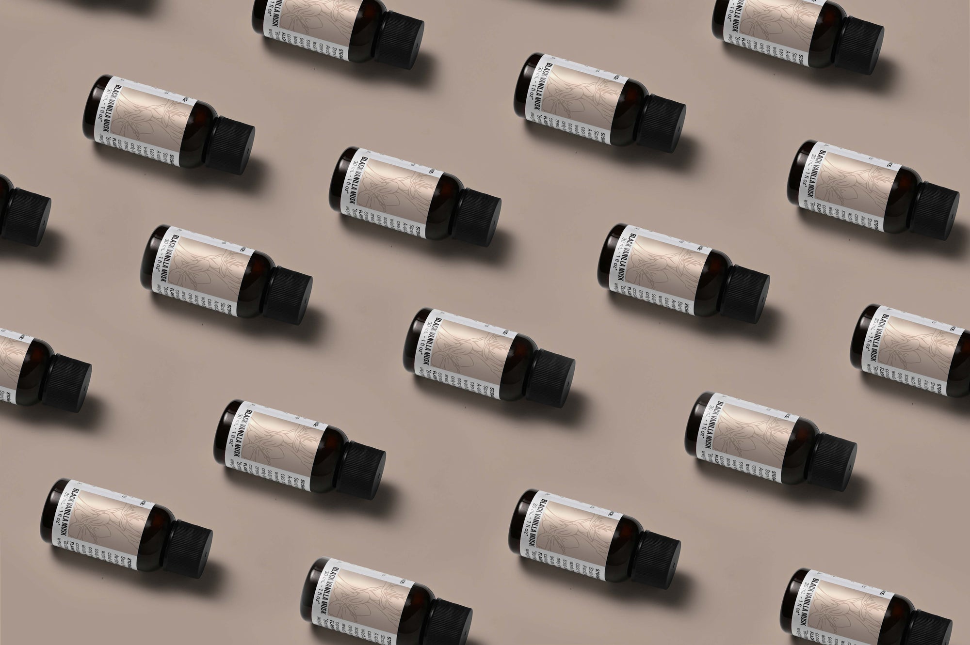 Pattern of Black Vanilla Musk fragrance oil bottles on a champagne background