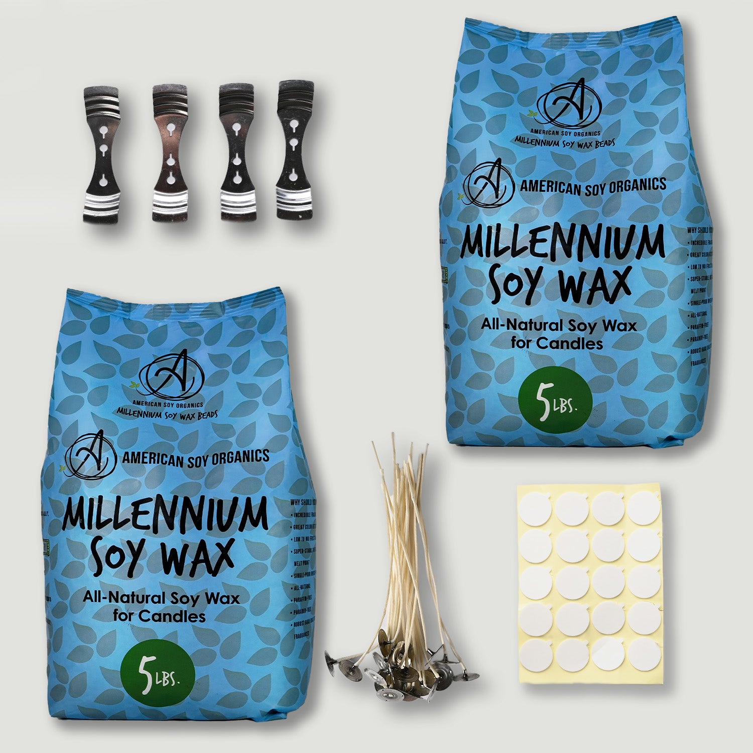 Two bags of American Soy Organics Millennium Soy Wax, candle wicks, and a sheet of stickers on a light gray background.