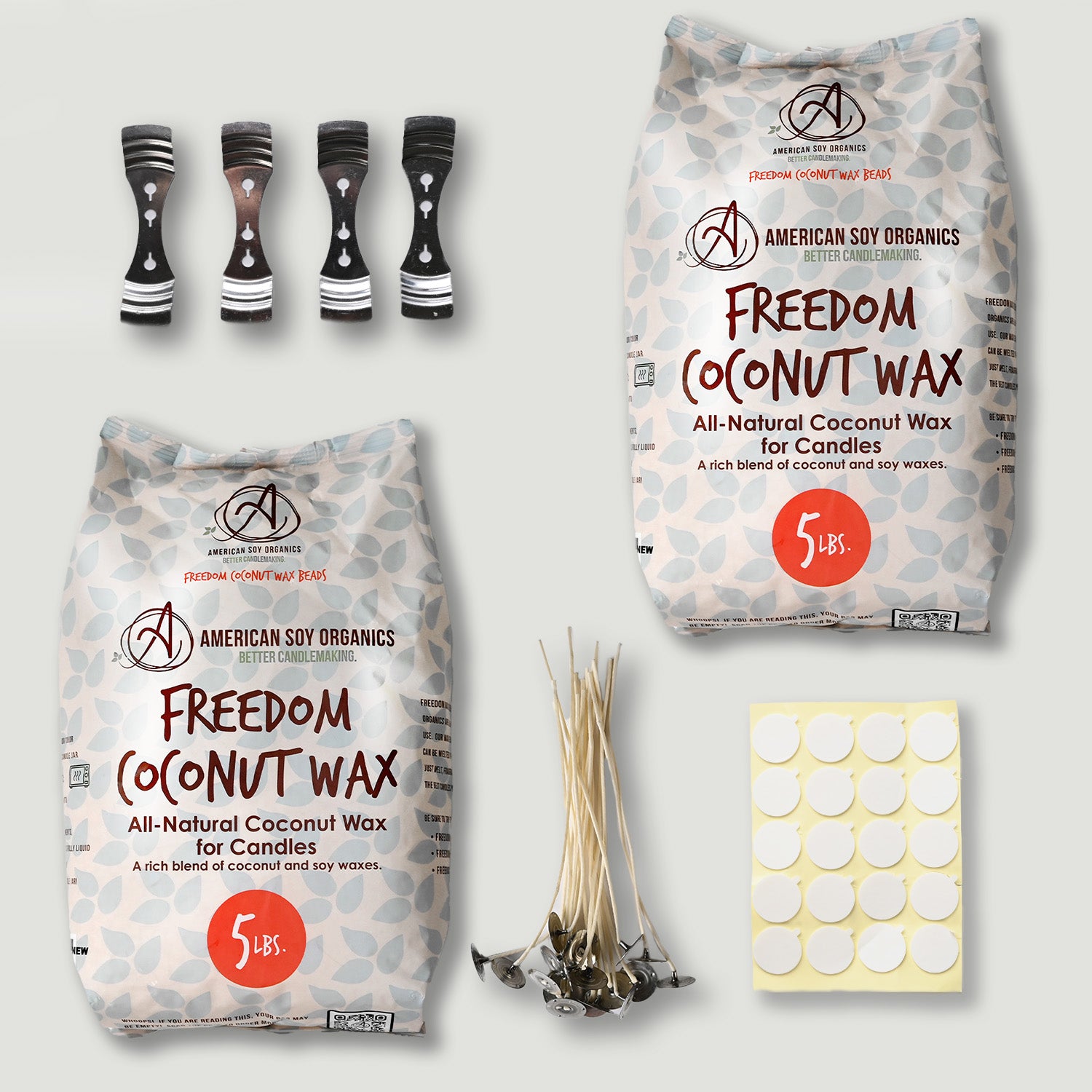 Two packages of American Soy Organics Freedom Coconut Wax, candle wicks, and a sheet of stickers on a light gray background.