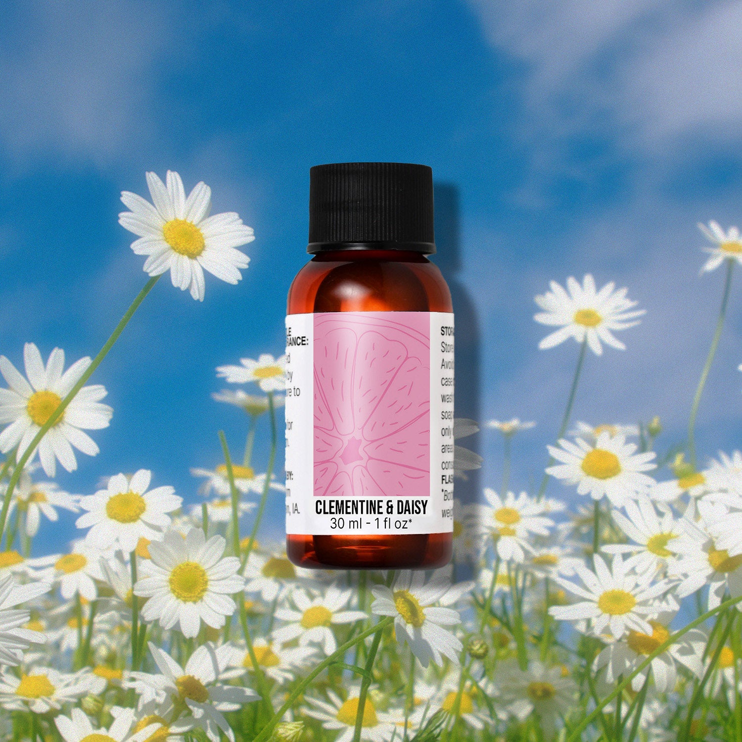 Bottle of Clementine & Daisy fragrance oil with daisies in the background