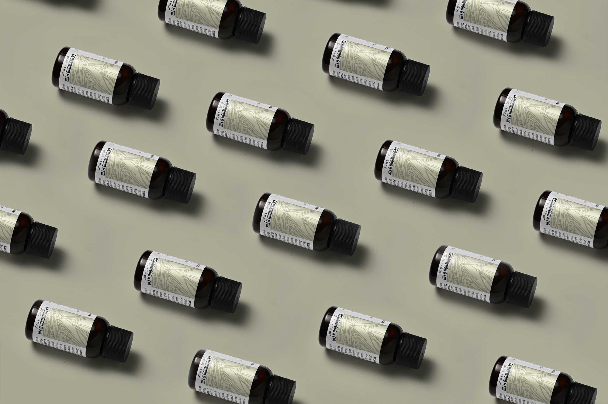 Pattern of Cedarwood & Fir fragrance oil bottles on a champagne colored background