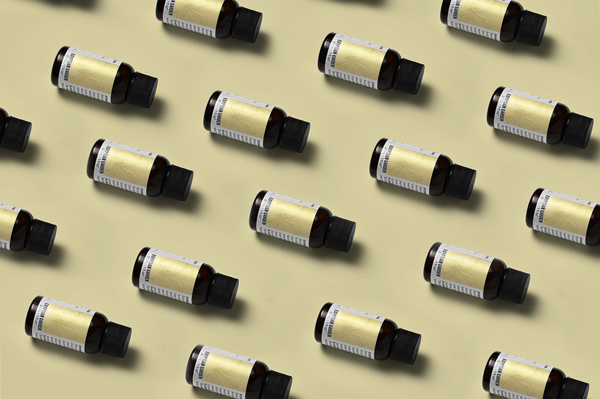 Pattern of Egyptian Garden fragrance oil bottles on a butter yellow background