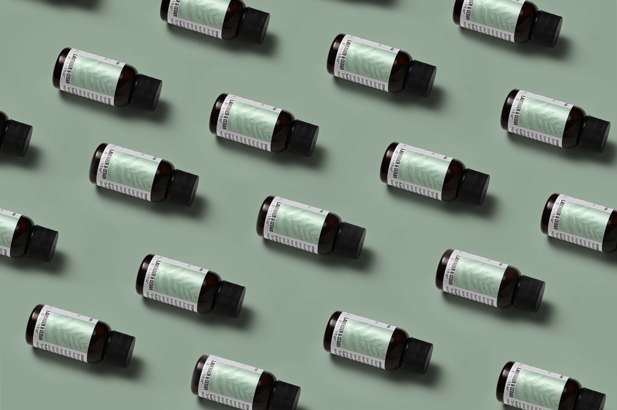 Pattern of Lavender Cedar fragrance oil bottles on a light green background