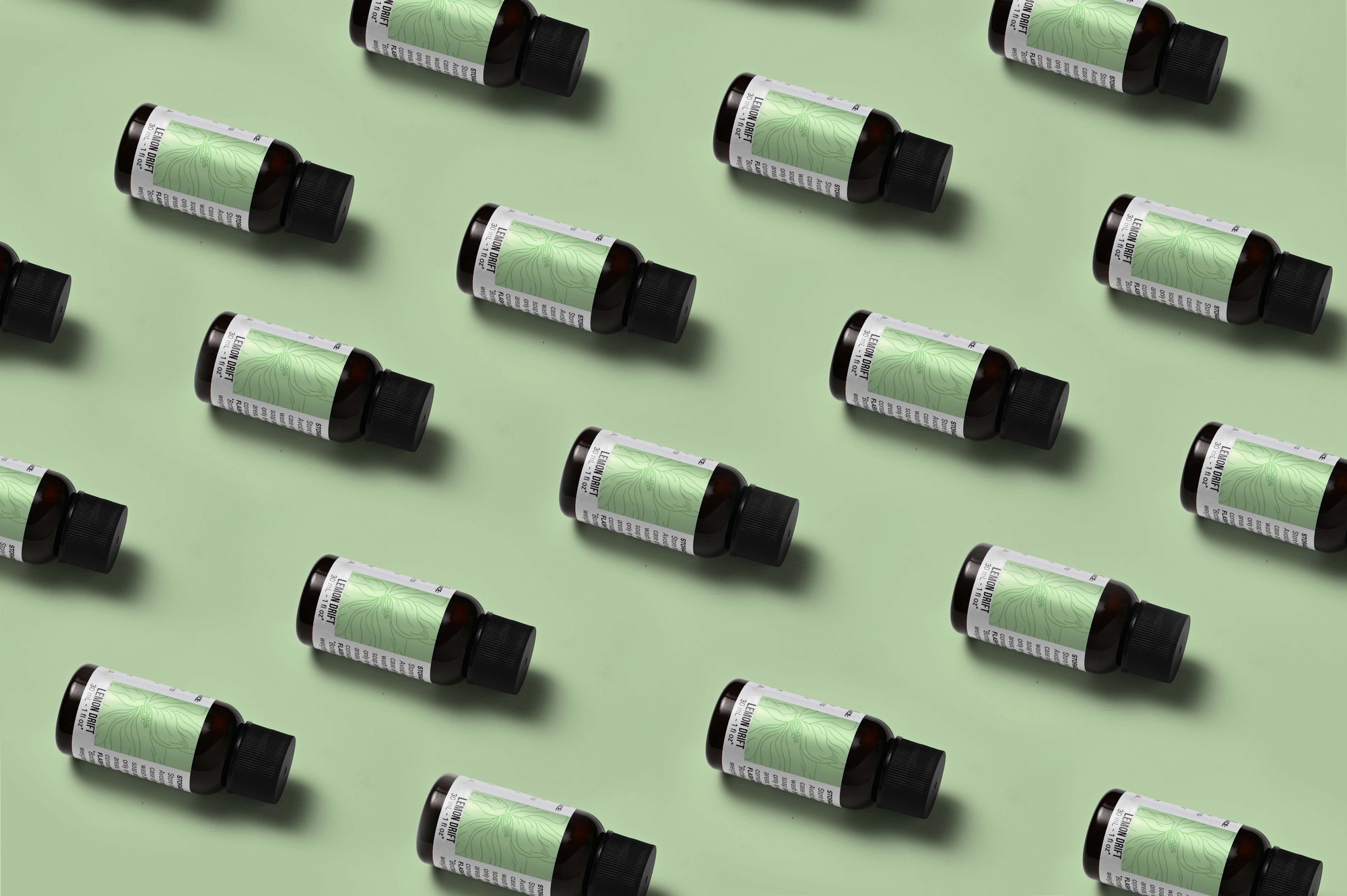 Pattern of Lemon Drift fragrance oil bottles on a light green background