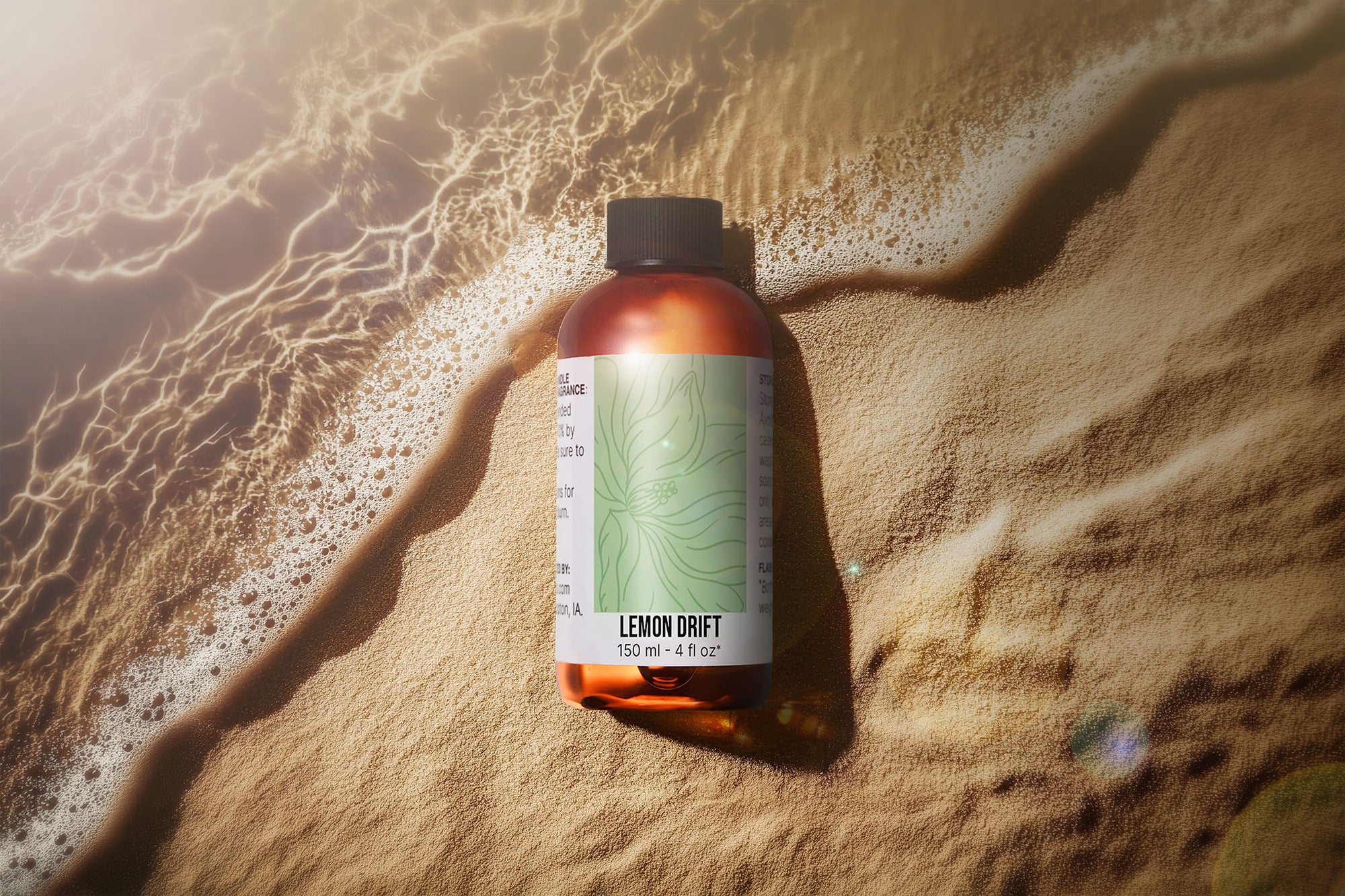 A bottle of Fragrance oil on a sandy beach.
