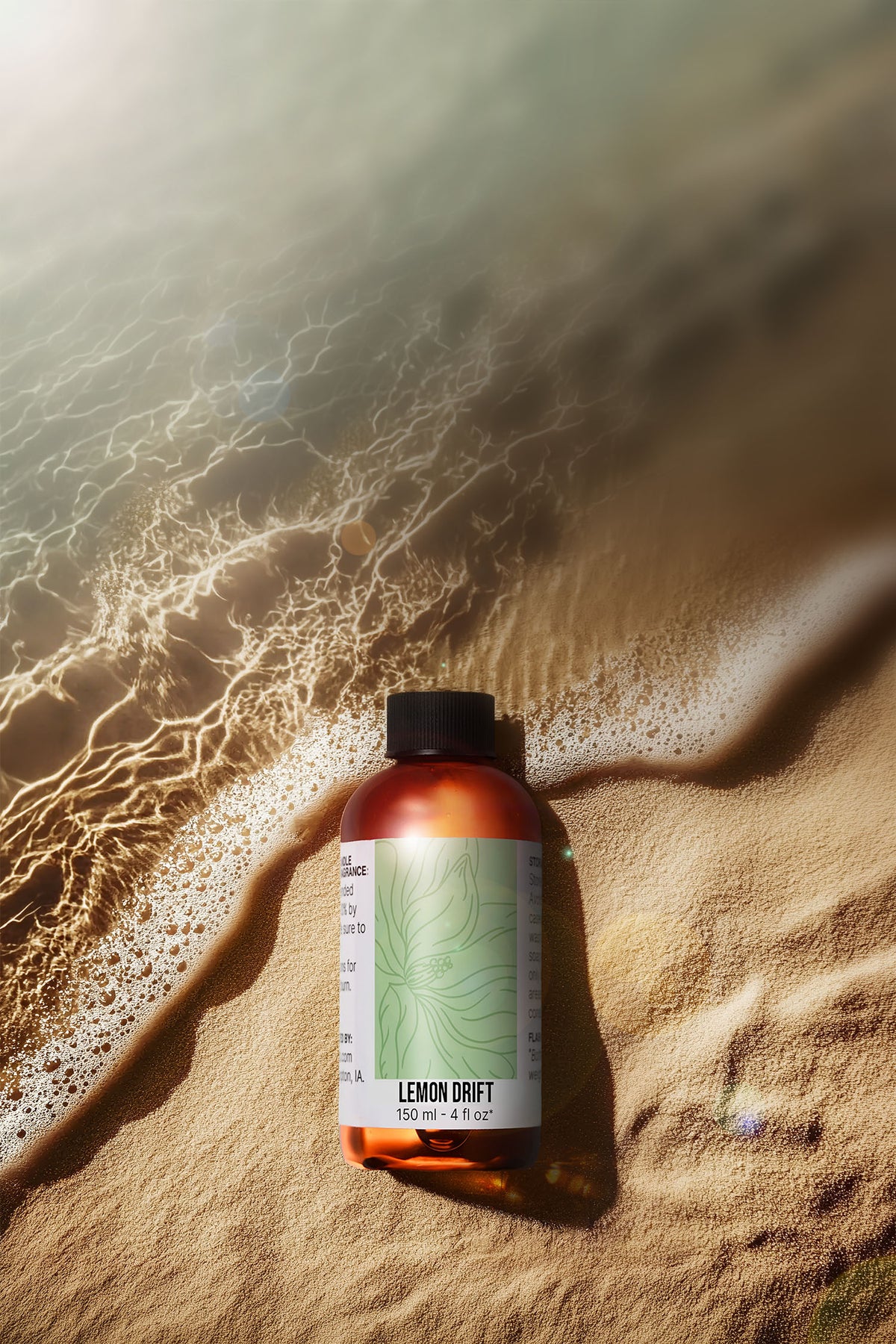 A bottle of Fragrance oil on a sandy beach.