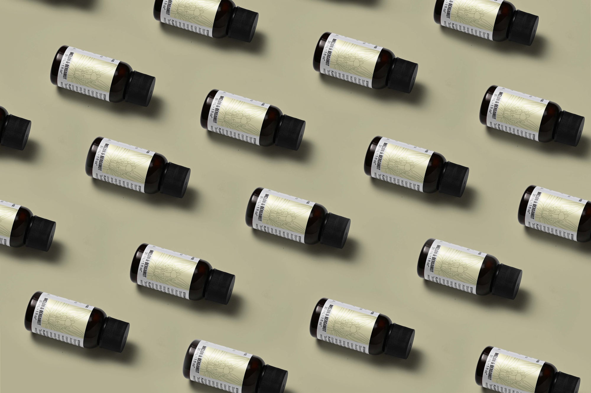 Pattern of Melon & Bergamot fragrance oil bottles on a champagne colored background