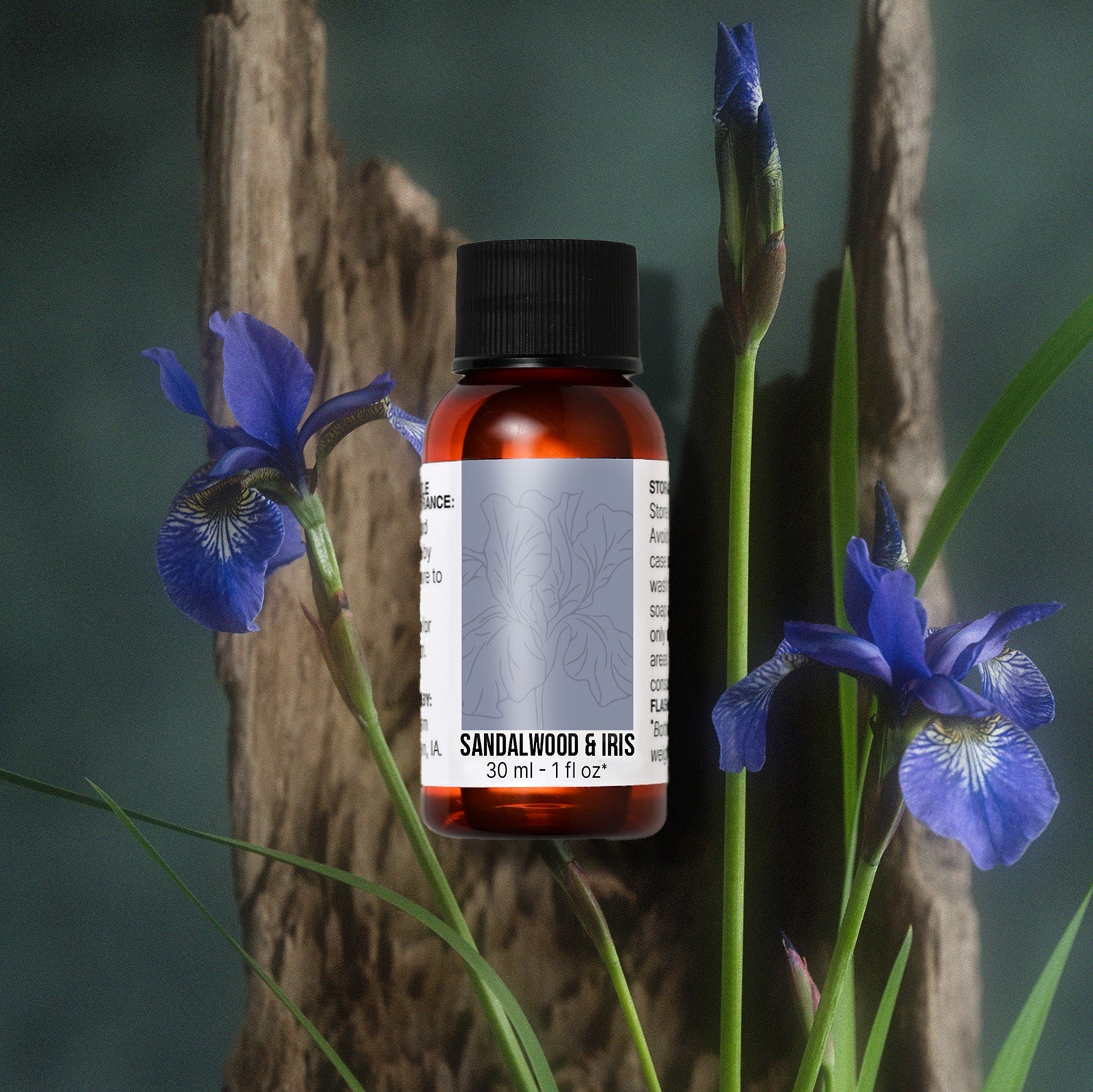 Sandalwood & Iris fragrance oil bottle surrounded by blue iris flowers and greenery