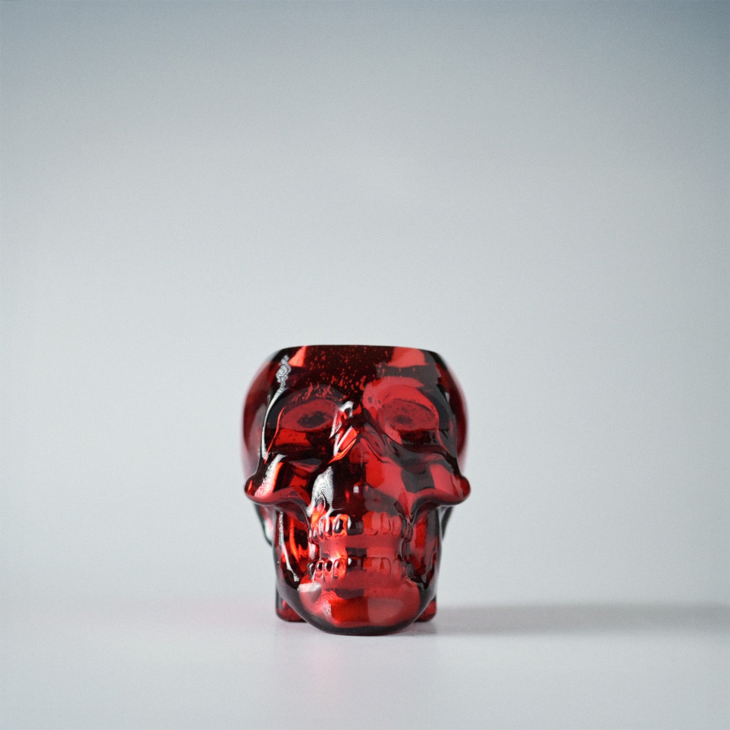 Red skull-shaped jar on a white background