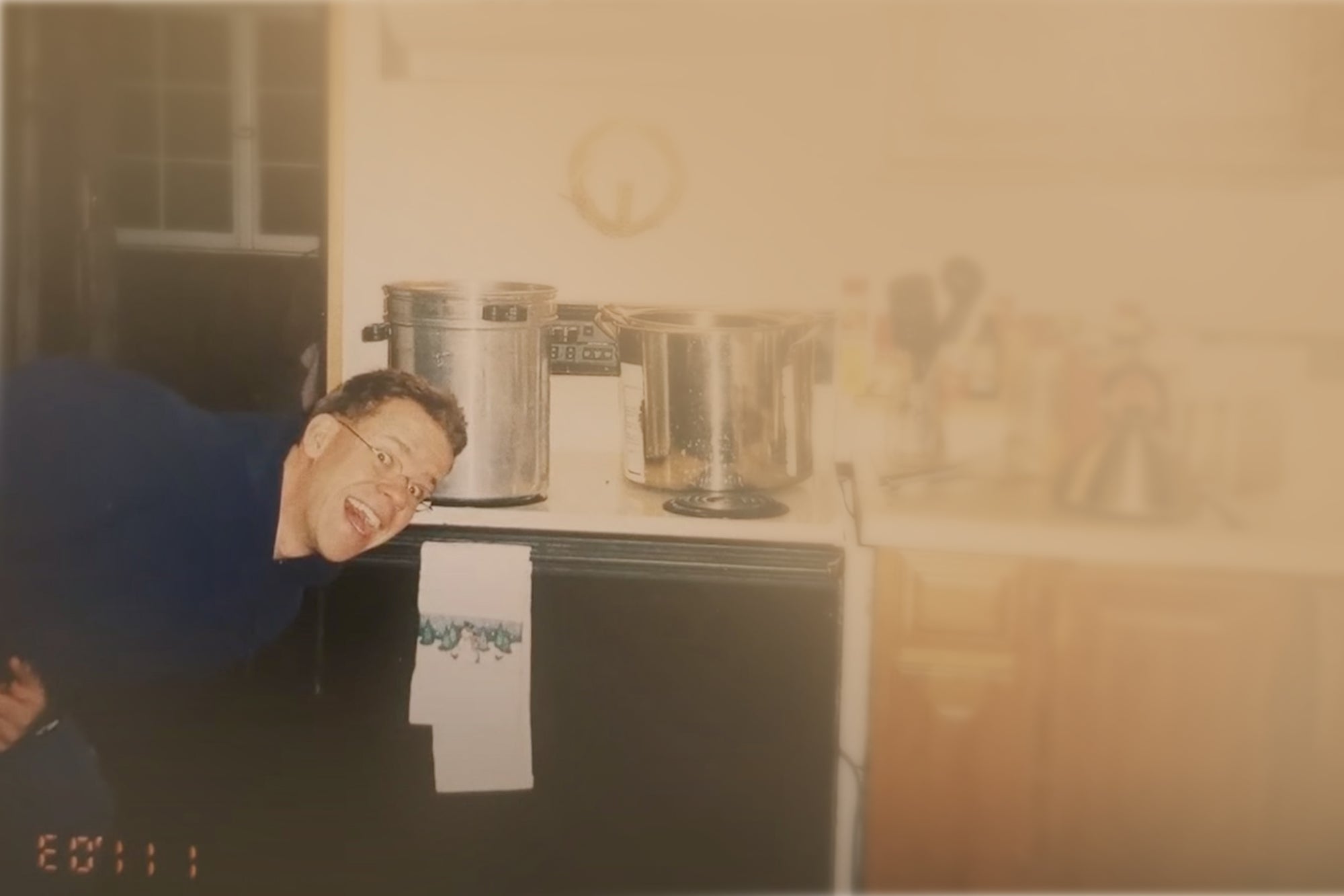 Person in front of a stove with pots on top in a kitchen setting