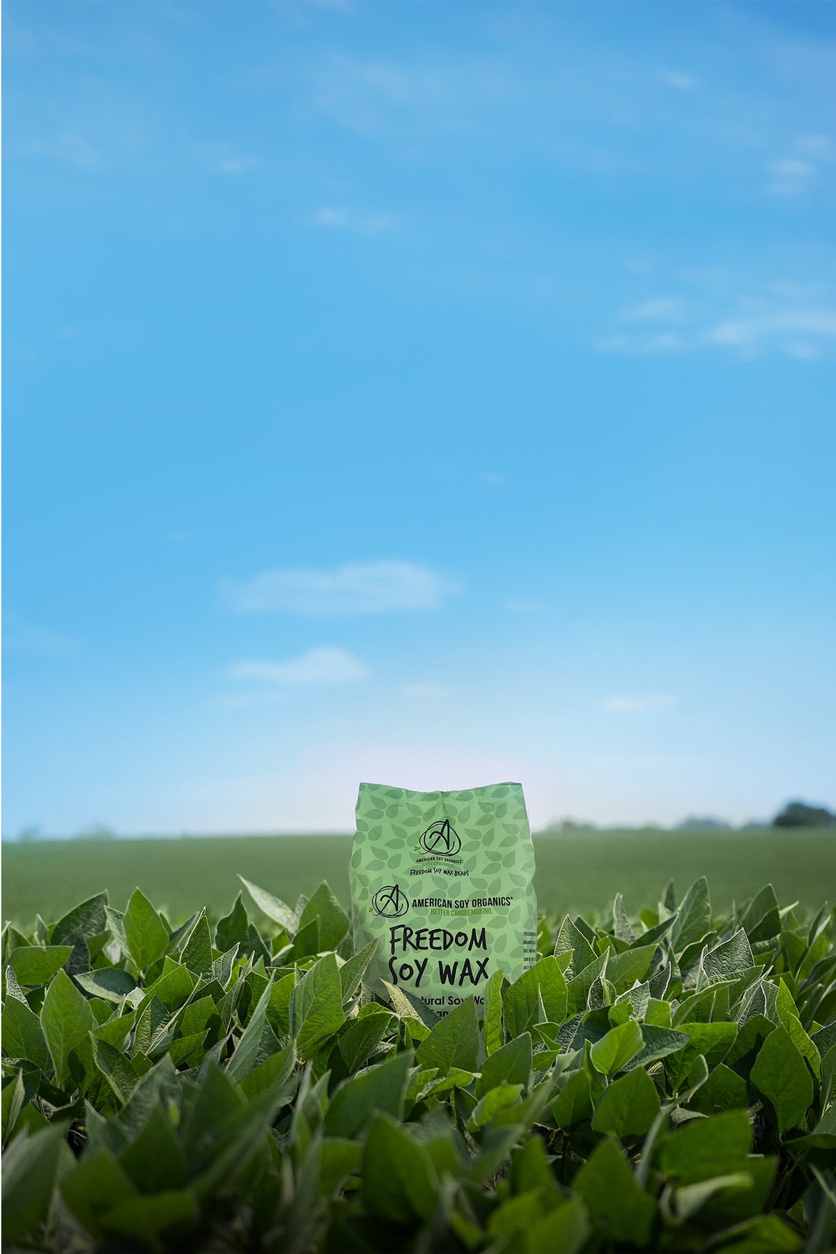 Green bag with text standing in a field under a blue sky