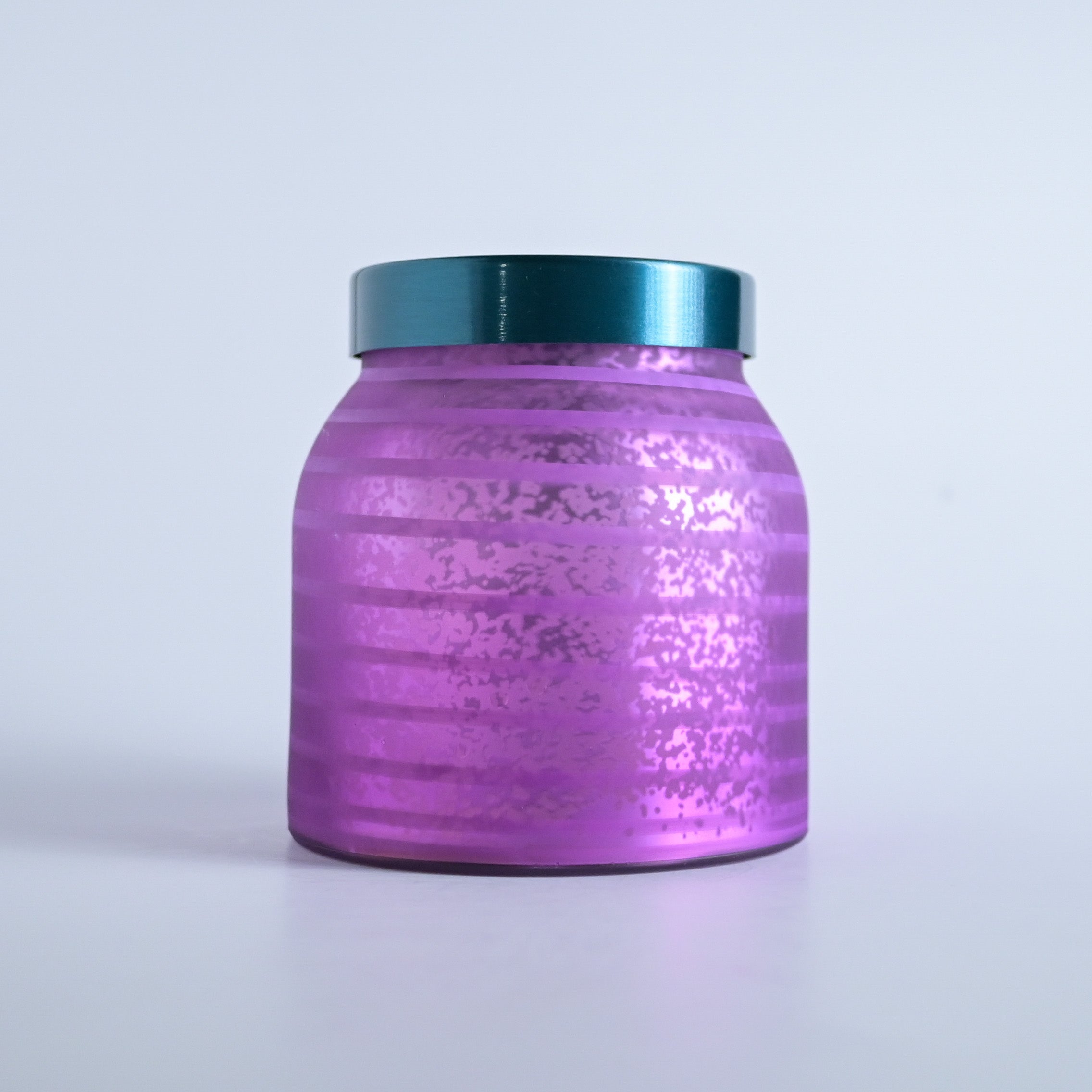 Purple striped jar with a teal lid on a white background