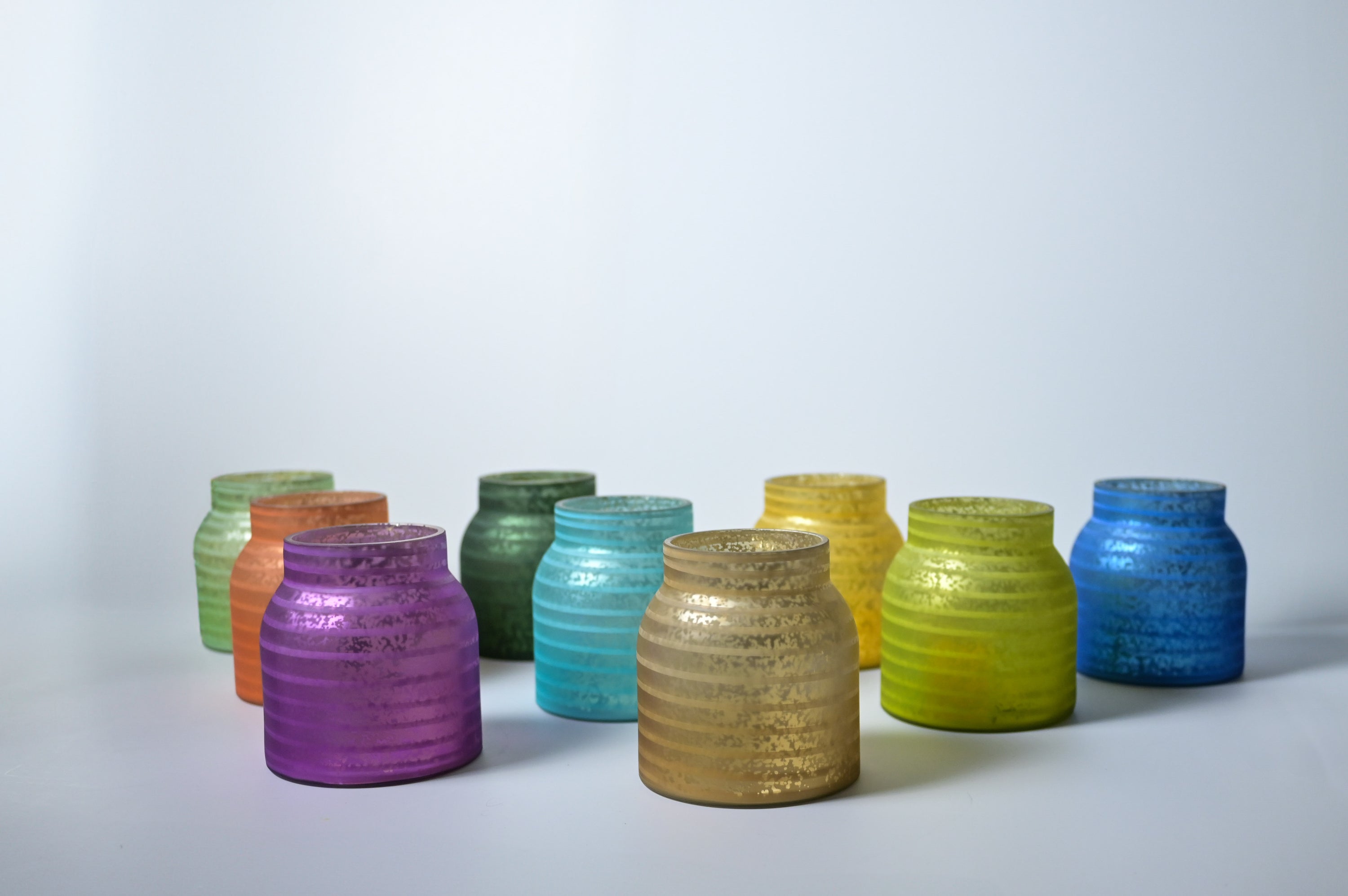 Colorful ceramic stripe jars on a white background
